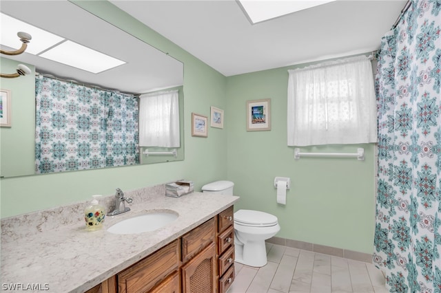 bathroom with a healthy amount of sunlight, tile flooring, vanity, and toilet