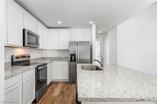 kitchen featuring light stone countertops, dark hardwood / wood-style flooring, sink, white cabinetry, and appliances with stainless steel finishes