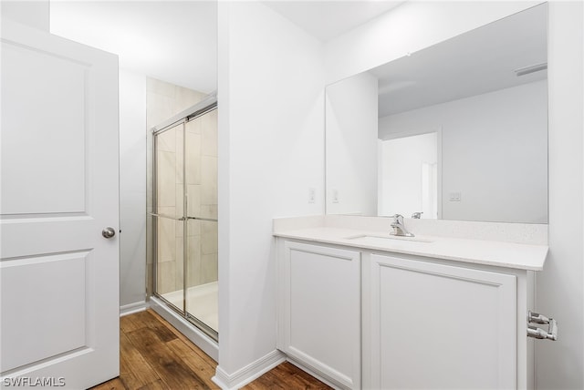 bathroom featuring an enclosed shower, vanity, and hardwood / wood-style floors