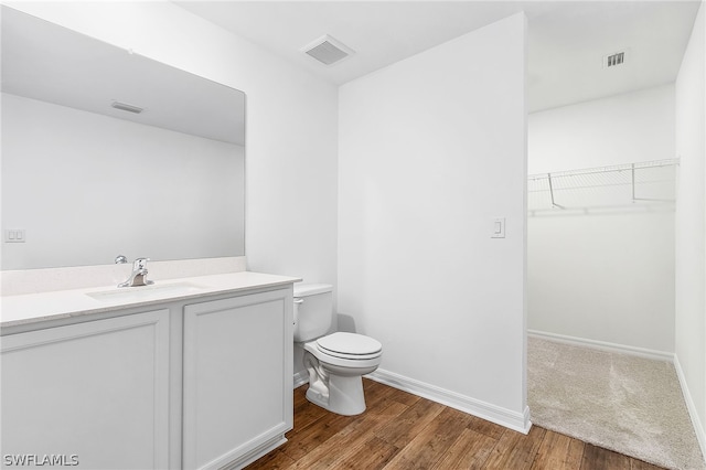 bathroom featuring hardwood / wood-style flooring, toilet, and vanity