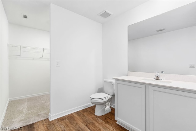 bathroom with hardwood / wood-style flooring, toilet, and vanity