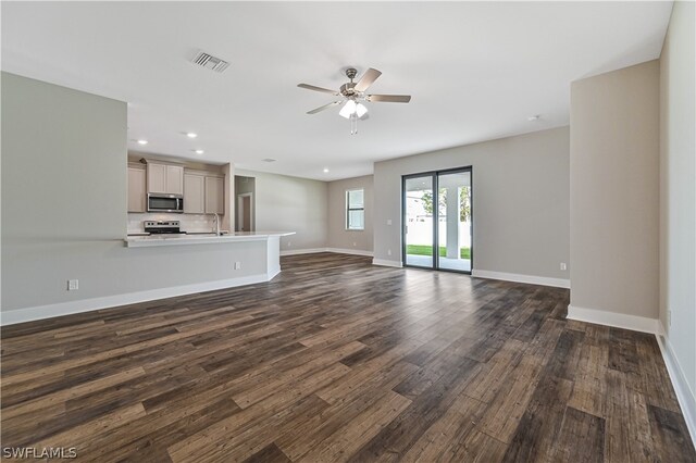 unfurnished living room featuring sink, ceiling fan, and dark hardwood / wood-style floors