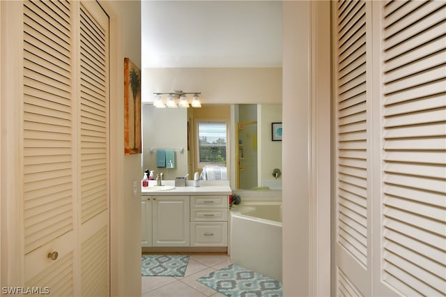 bathroom with tile floors, a bathtub, and vanity