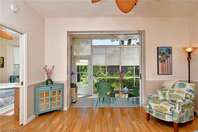 sitting room with light wood-type flooring and ceiling fan