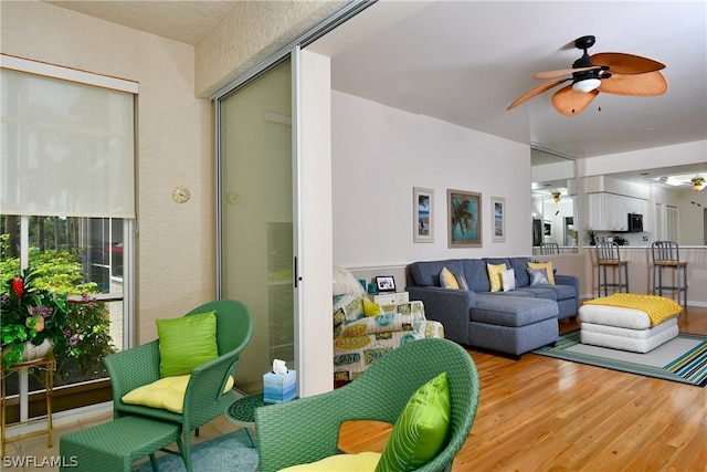 living room with ceiling fan and light wood-type flooring