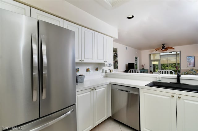 kitchen with appliances with stainless steel finishes, white cabinets, sink, ceiling fan, and light tile floors