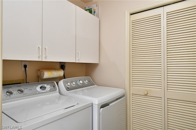 laundry room with separate washer and dryer, electric dryer hookup, and cabinets