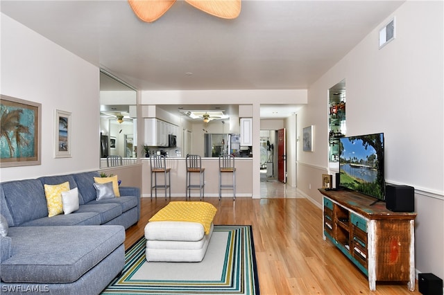 living room with light wood-type flooring and ceiling fan