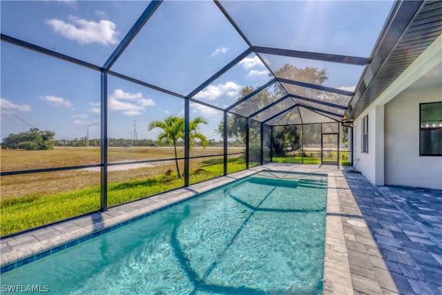 view of swimming pool featuring a lawn and glass enclosure