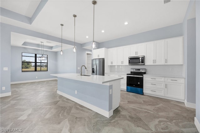 kitchen with white cabinetry, a center island with sink, appliances with stainless steel finishes, pendant lighting, and a raised ceiling