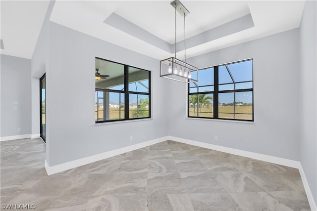 spare room with a raised ceiling and tile flooring