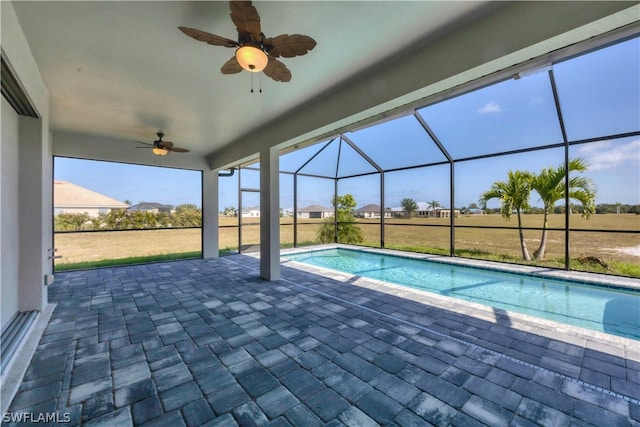 view of pool featuring ceiling fan, glass enclosure, and a patio