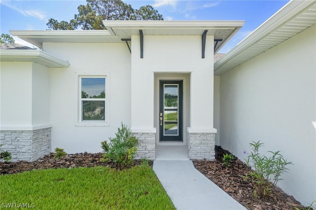 entrance to property featuring a yard