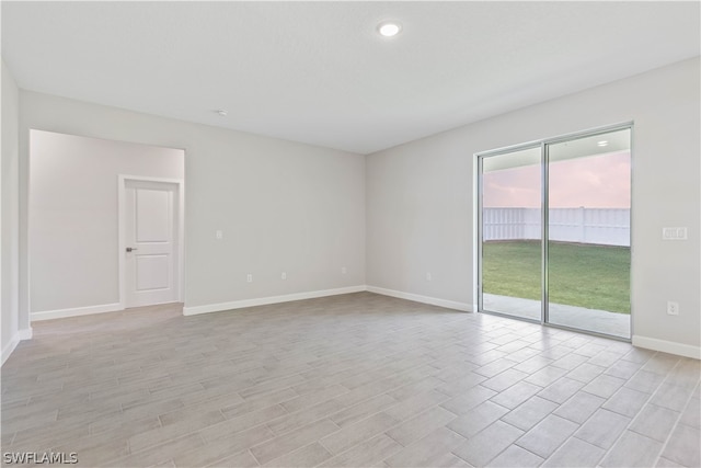 empty room with plenty of natural light and light hardwood / wood-style floors