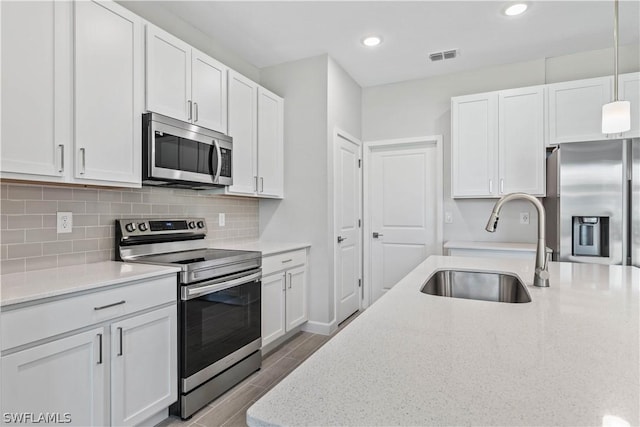 2206 NW 17th Pl, Cape Coral, FL 33993 - kitchen with a sink, visible vents, white cabinetry, backsplash, and appliances with stainless steel finishes