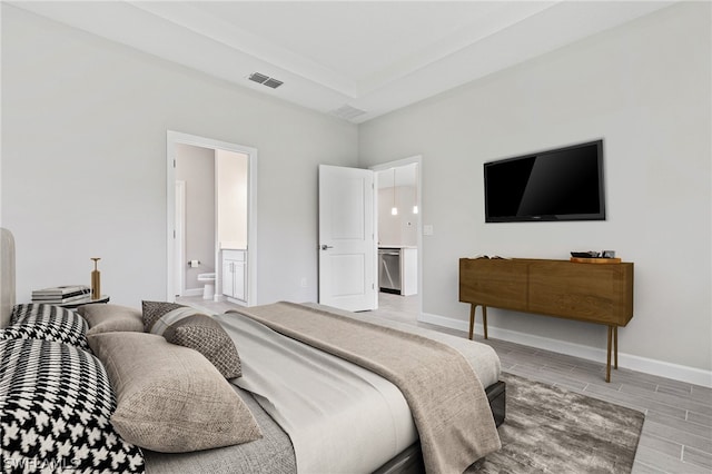 bedroom featuring light hardwood / wood-style flooring and ensuite bath