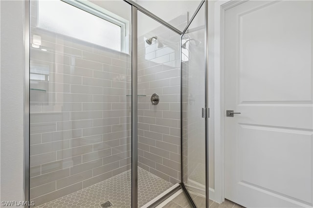 bathroom with tile patterned floors and a shower with door