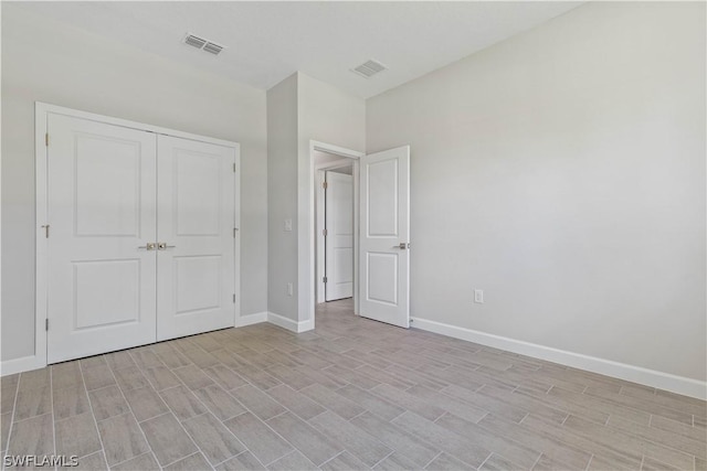 2206 NW 17th Pl, Cape Coral, FL 33993 - unfurnished bedroom featuring baseboards, visible vents, wood finish floors, and a closet