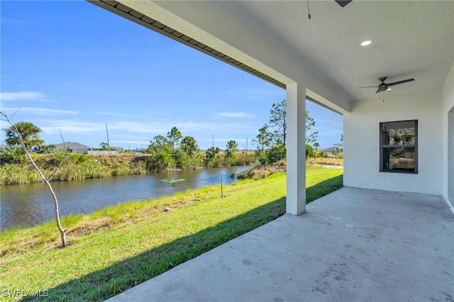 view of patio featuring a water view and ceiling fan