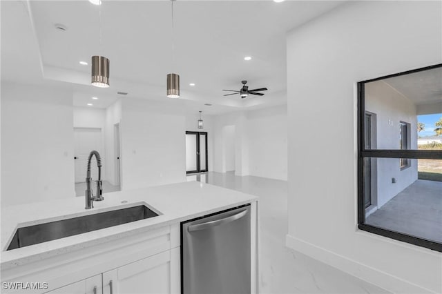 kitchen featuring stainless steel dishwasher, ceiling fan, sink, pendant lighting, and white cabinets