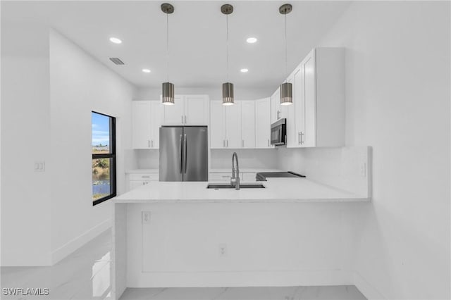 kitchen with kitchen peninsula, white cabinetry, sink, and stainless steel appliances