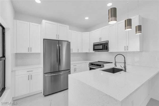 kitchen featuring white cabinets, appliances with stainless steel finishes, decorative light fixtures, and sink