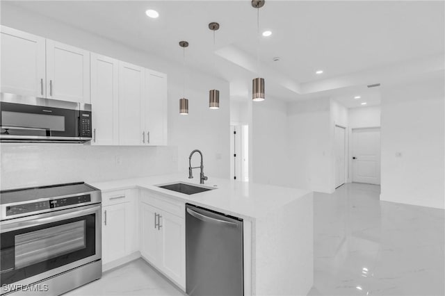 kitchen featuring kitchen peninsula, decorative light fixtures, stainless steel appliances, and white cabinetry