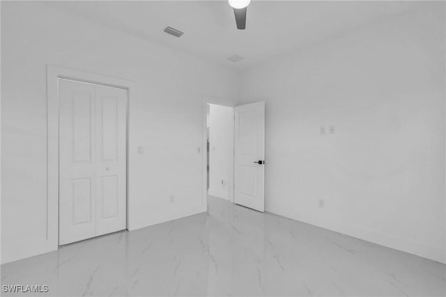 unfurnished bedroom featuring ceiling fan and a closet