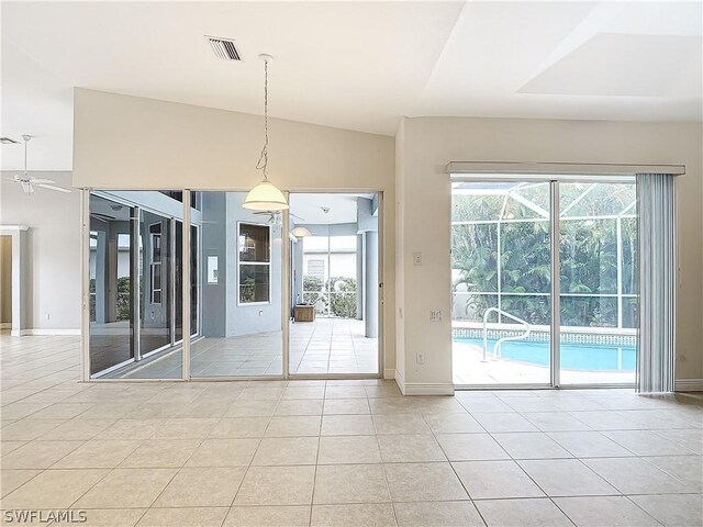 tiled spare room with ceiling fan, lofted ceiling, and a wealth of natural light