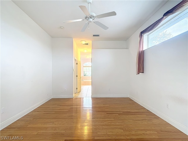 spare room with light hardwood / wood-style floors, ceiling fan, and a healthy amount of sunlight