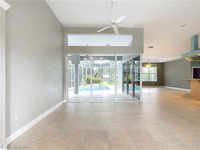 empty room featuring a high ceiling, ceiling fan, and light tile patterned floors