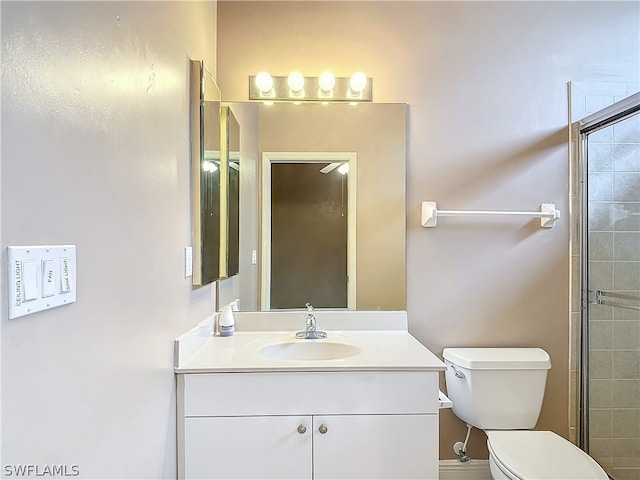 bathroom featuring vanity, a shower with door, and toilet