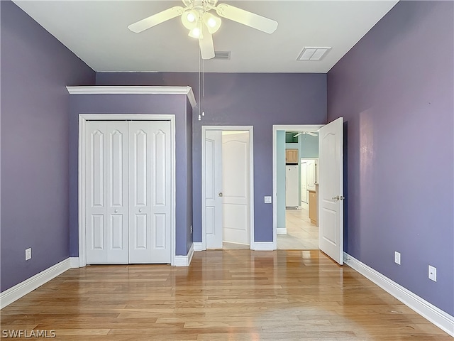 unfurnished bedroom with light hardwood / wood-style floors, a closet, and ceiling fan