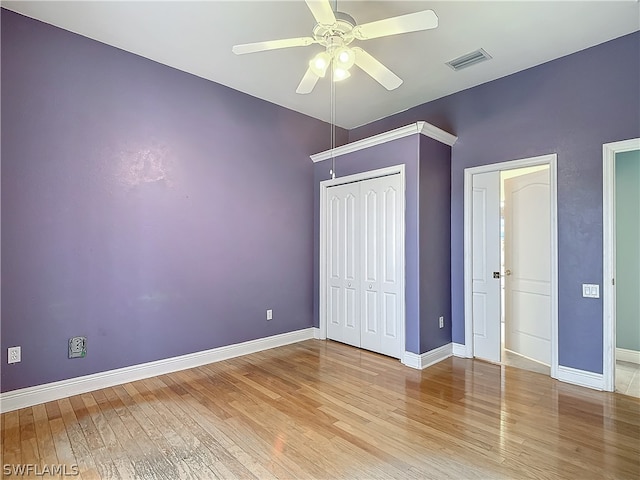 unfurnished bedroom with ceiling fan, light hardwood / wood-style flooring, and a closet