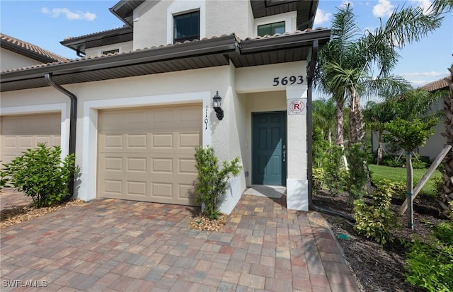 exterior space featuring decorative driveway and stucco siding