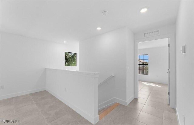 hall with light tile patterned floors, recessed lighting, visible vents, an upstairs landing, and baseboards