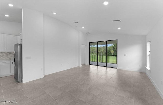 spare room featuring lofted ceiling, baseboards, visible vents, and recessed lighting