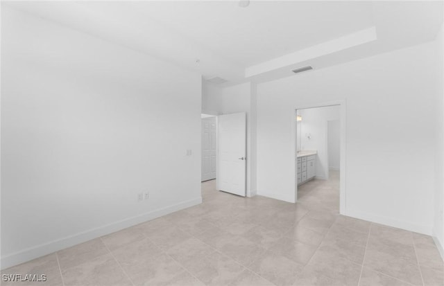 unfurnished bedroom featuring visible vents, ensuite bath, and baseboards