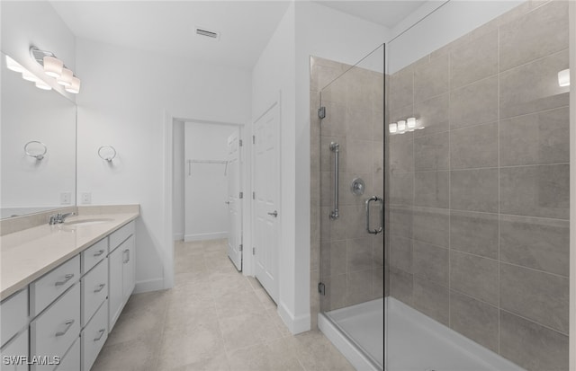 bathroom with vanity, walk in shower, and tile patterned flooring