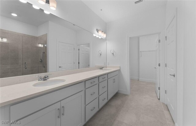 bathroom featuring vanity, an enclosed shower, and tile patterned floors