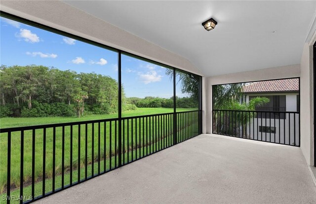 unfurnished sunroom with lofted ceiling