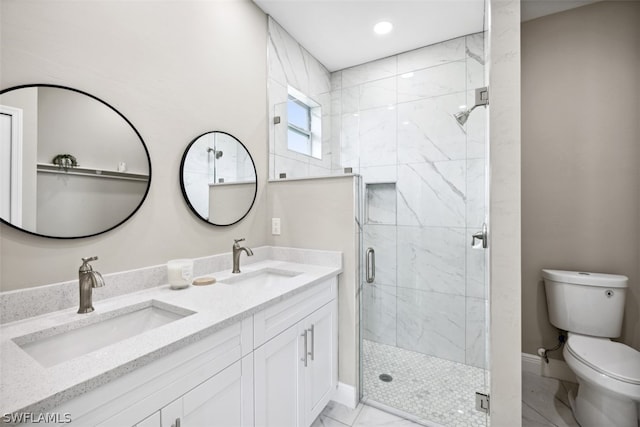 bathroom featuring vanity, a shower with shower door, and toilet