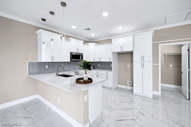 kitchen featuring sink, white cabinets, ornamental molding, tasteful backsplash, and hanging light fixtures