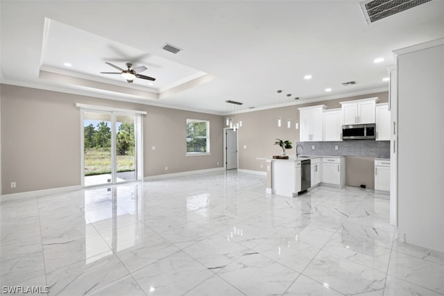 kitchen featuring white cabinetry, dishwasher, ornamental molding, hanging light fixtures, and a tray ceiling