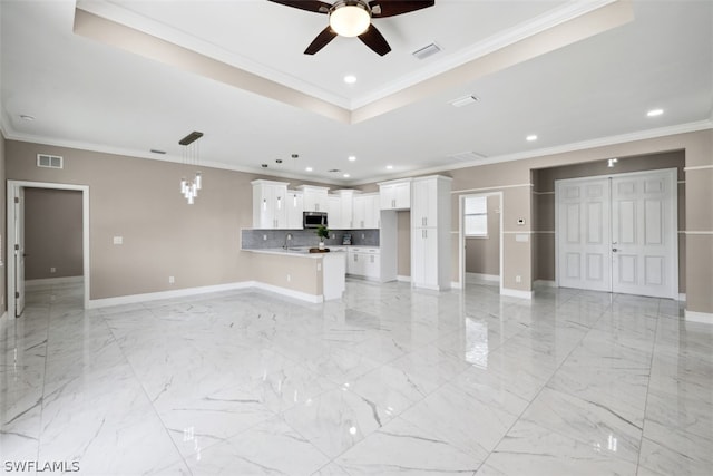 unfurnished living room with ceiling fan, crown molding, sink, and a tray ceiling