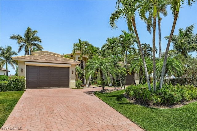 mediterranean / spanish house with a front yard and a garage