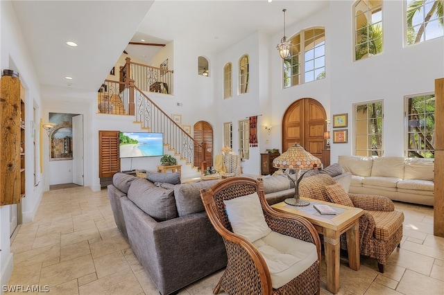 living room featuring a high ceiling, plenty of natural light, and light tile floors