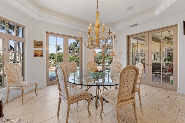 tiled dining space featuring a raised ceiling, an inviting chandelier, and french doors