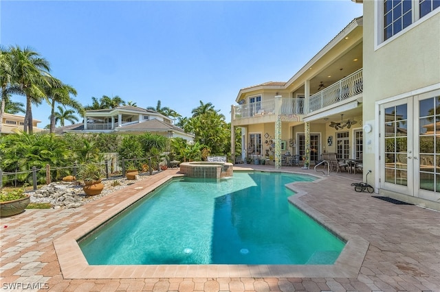 view of swimming pool featuring a patio, an in ground hot tub, and french doors