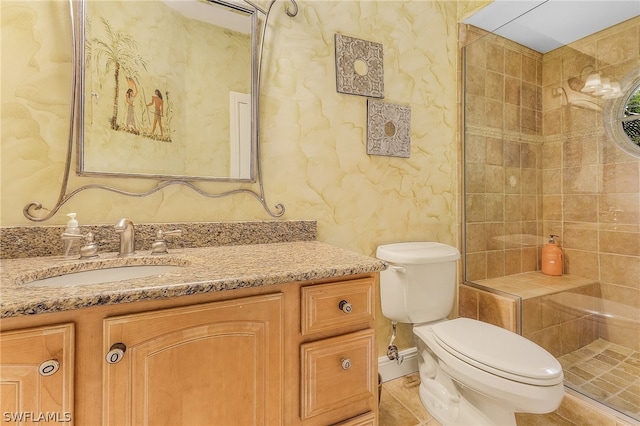 bathroom featuring tiled shower, tile flooring, vanity, and toilet